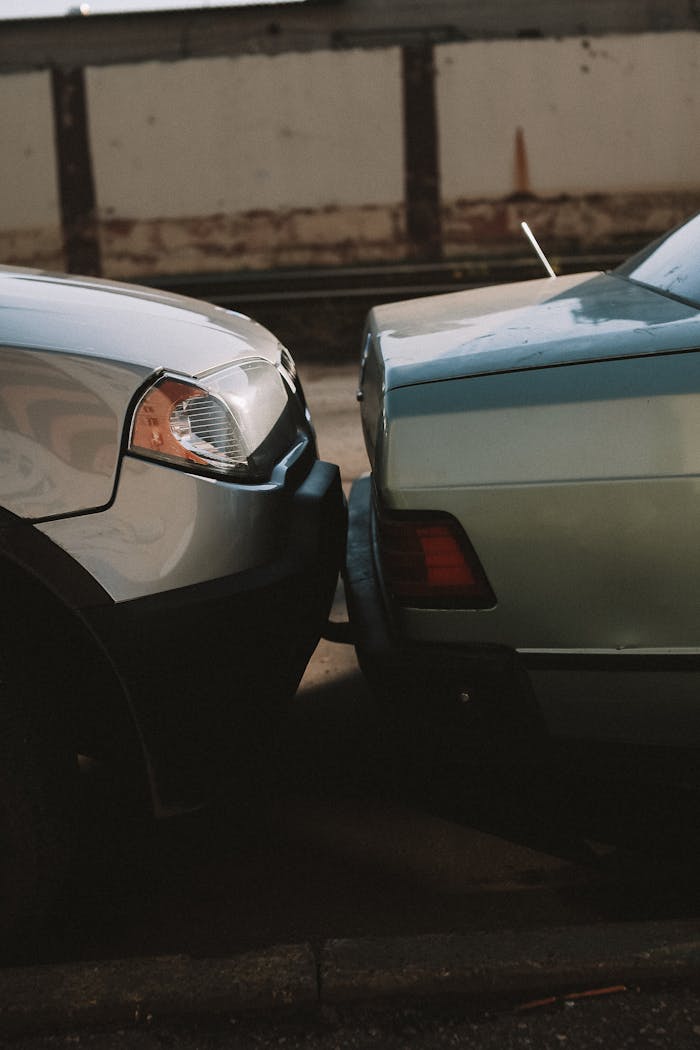 A close-up view showing the aftermath of a rear-end car collision in an outdoor setting.
